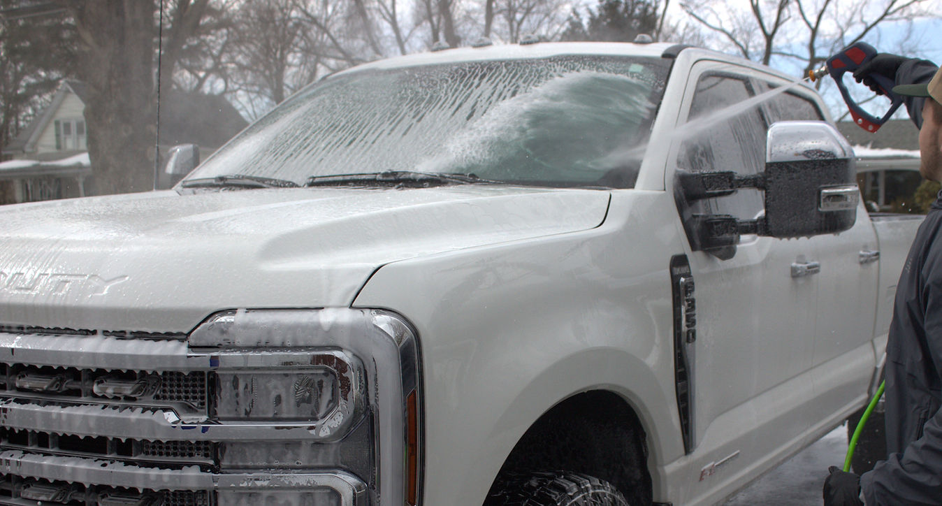 Suds washing a white pickup truck at a customer's location